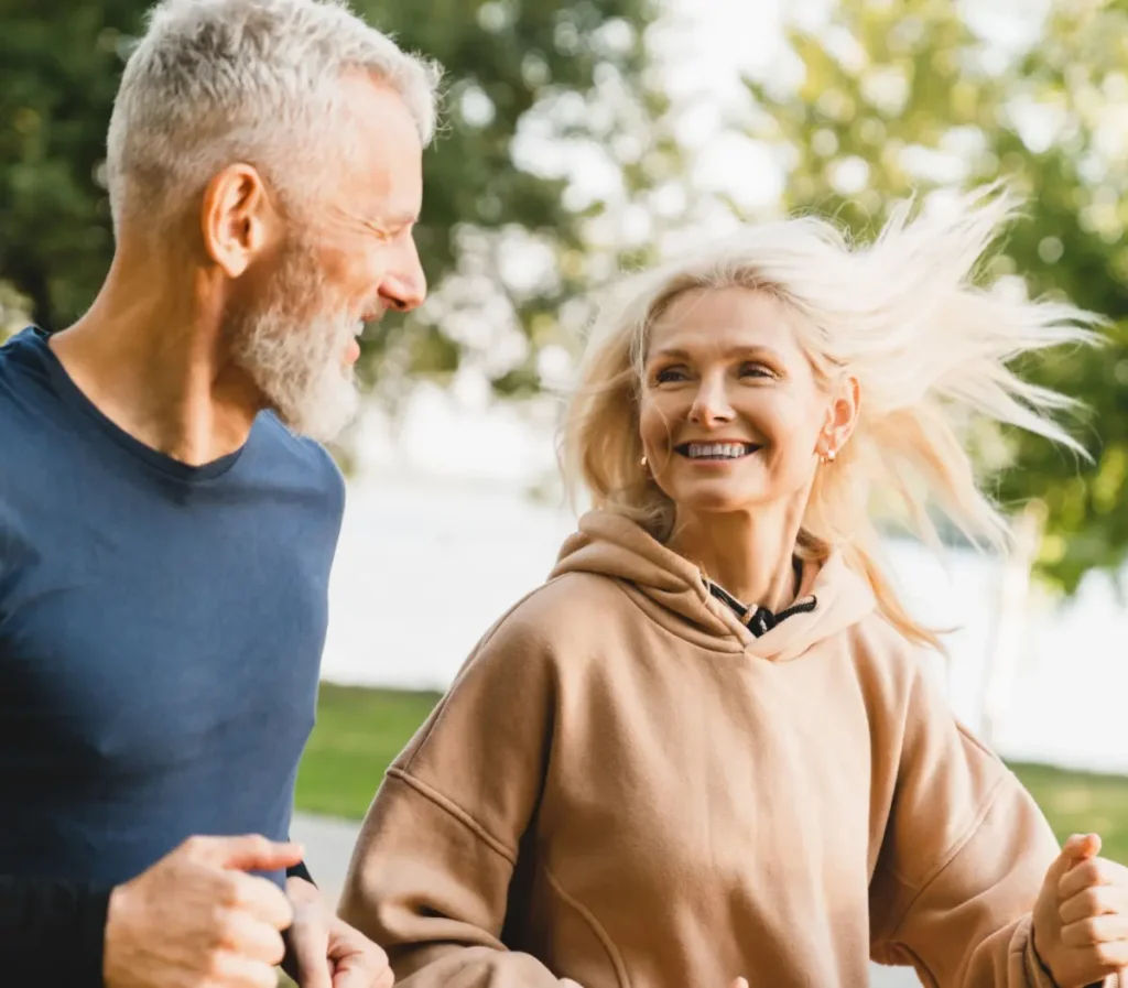 senior couple running together in the park stadium