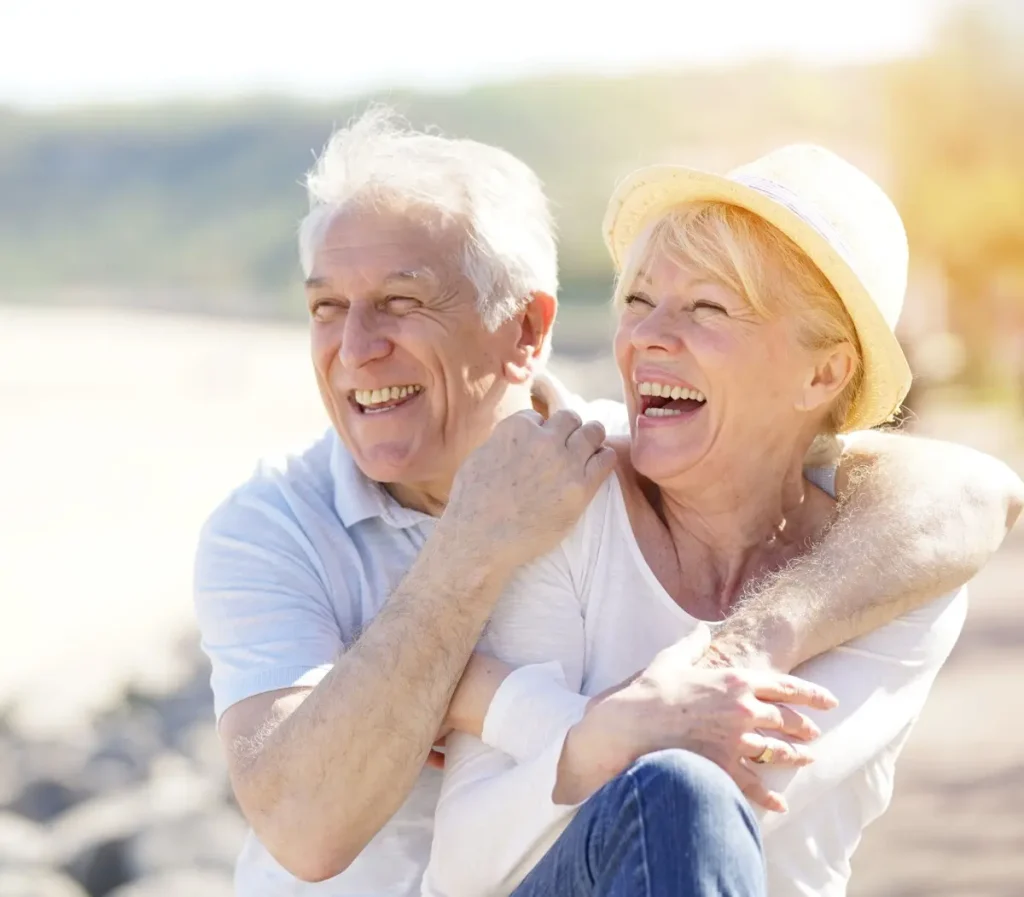 senior couple smiling by the lake