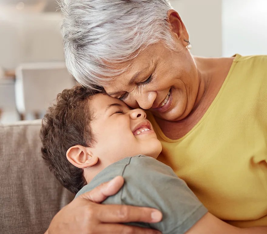 SENIOR WOMAN HUGGING CHILD